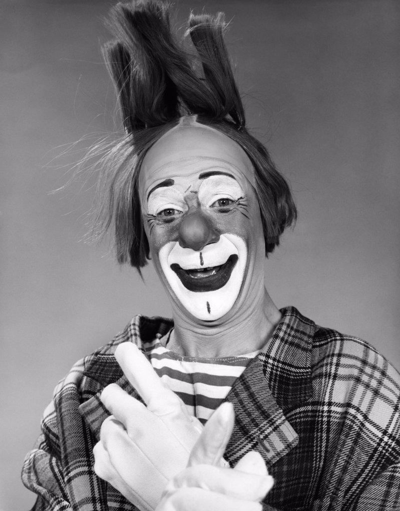 1960S Smiling Clown With White Gloved Crossed Hands And Hair Standing On End Studio Inside