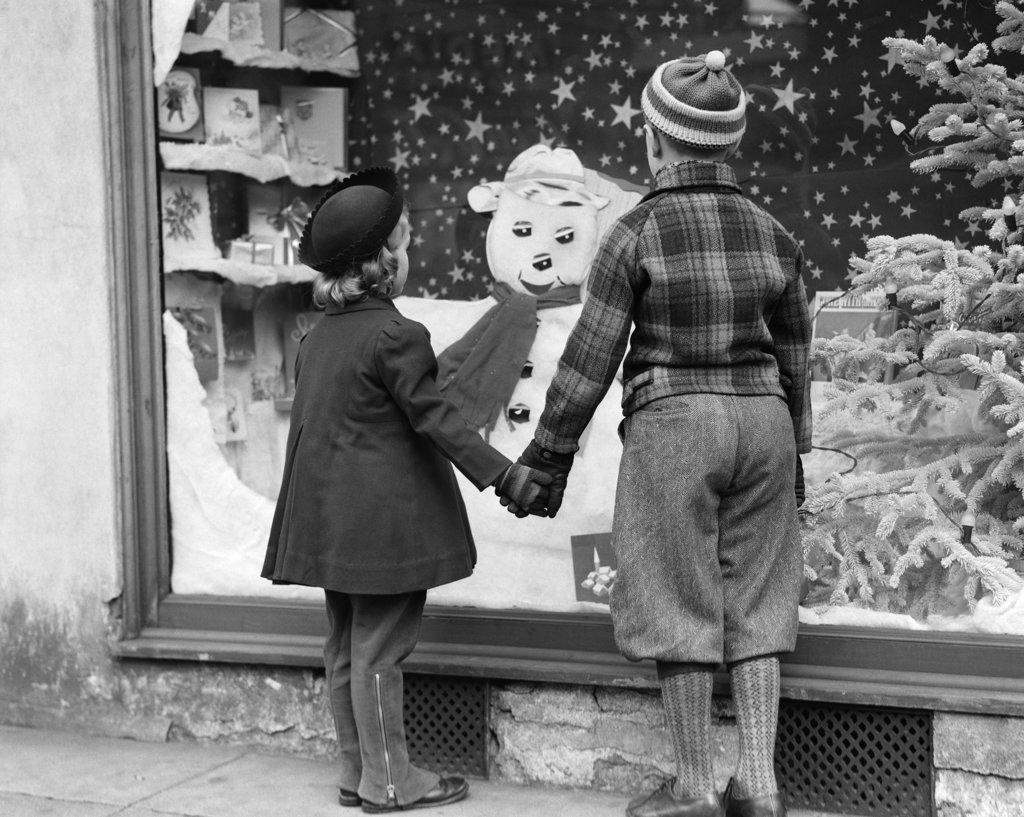 1930S Boy And Girl Holding Hands Looking At Decorated Christmas Window