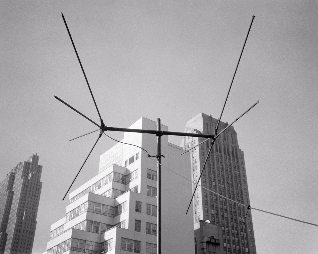 1950s 1960s TELEVISION ANTENNA BESIDE TALL SKYSCRAPER BUILDINGS
