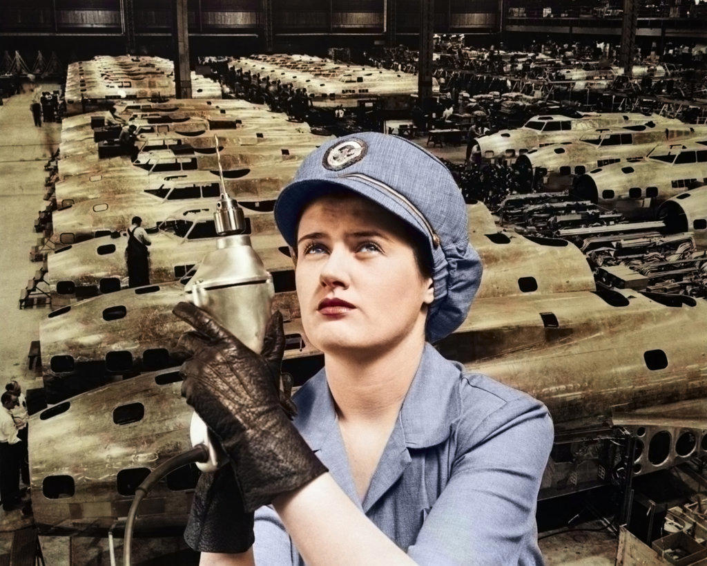 1940s WOMAN ROSIE THE RIVETER SUPERIMPOSED OVER AIRPLANES IN FACTORY 1940s WARTIME WWII
