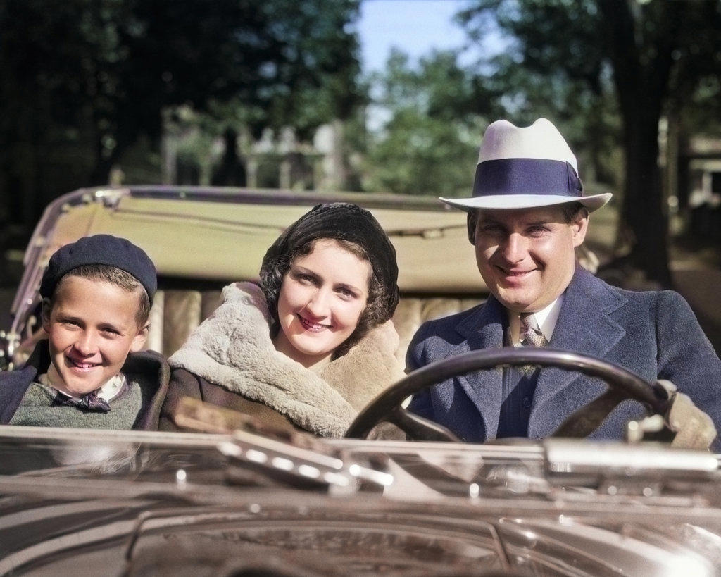 1930s SMILING FAMILY PORTRAIT MAN FATHER WOMAN MOTHER SON BOY RIDING IN CONVERTIBLE AUTOMOBILE ALL LOOKING AT CAMERA