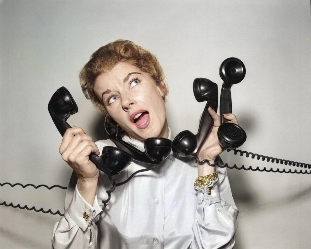 1950s 1960s OVERWHELMED STRESSED WOMAN HOLDING ANSWERING FOUR BLACK TELEPHONE PHONE RECEIVERS AT ONE TIME