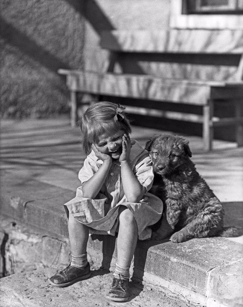 1930S Little Girl Sitting On Porch Stoop Funny Expression Hands Up To Her Face Beside Her Dog