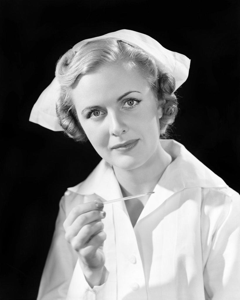 1930s PORTRAIT WOMAN  NURSE HOLDING THERMOMETER LOOKING AT CAMERA