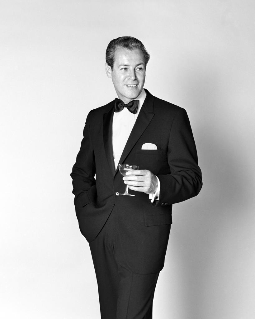 1960s SMILING MAN WEARING TUXEDO HOLDING CHAMPAGNE GLASS