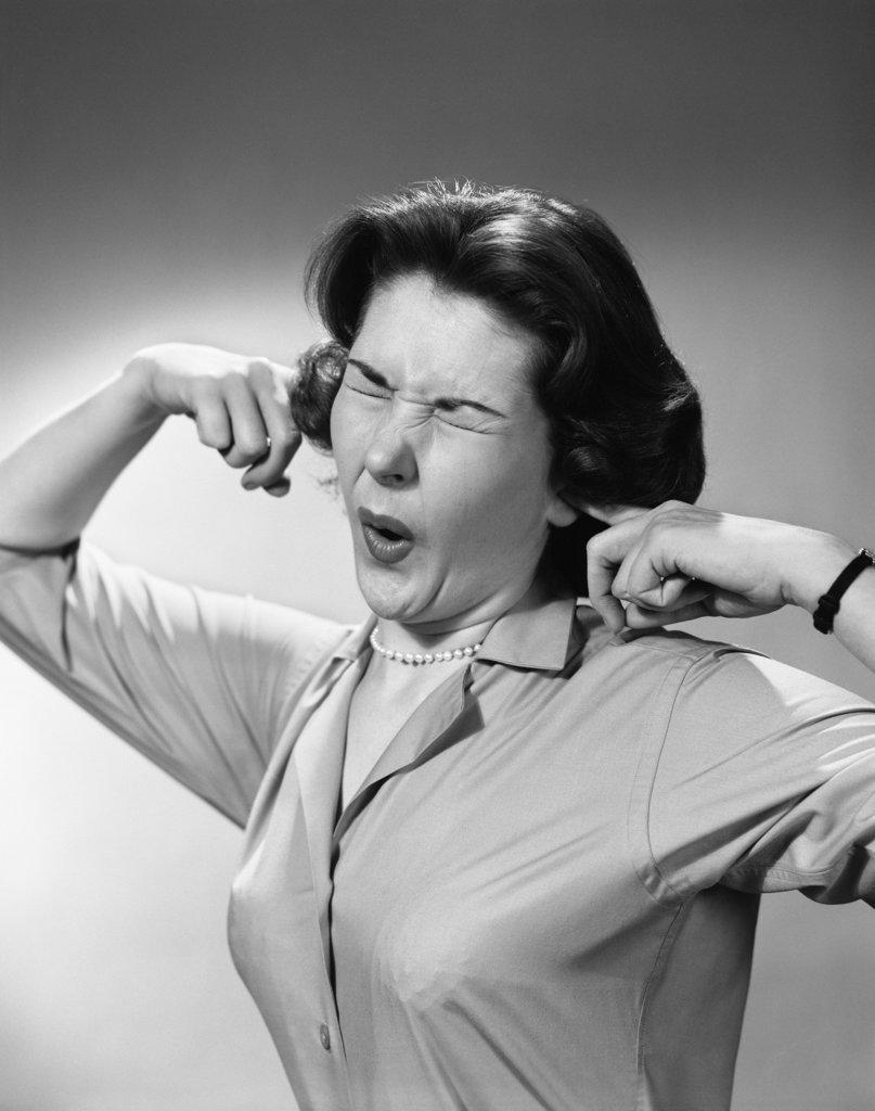 1950S Woman Sticking Fingers In Ears Eyes Closed Funny Facial Expression