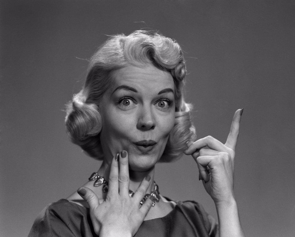 1950S Blond Woman Lips Pursed In Funny Facial Expression And Pointing Up With One Finger