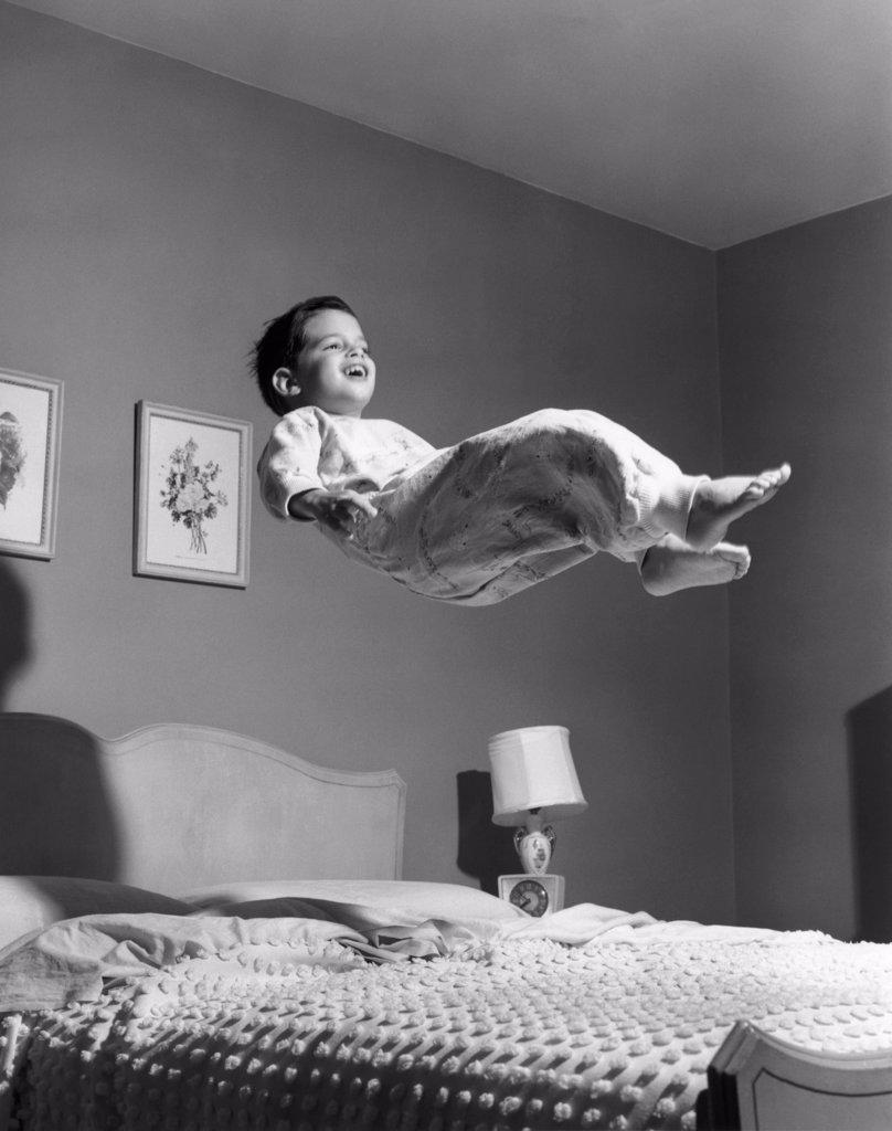 1950S Boy In Pajamas Elevated Above Bed