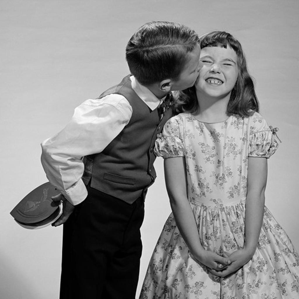 1950S 1960S Boy In Vest & Bow Tie Holding Valentine Candy Kissing Cheek Of Girl Making A Face