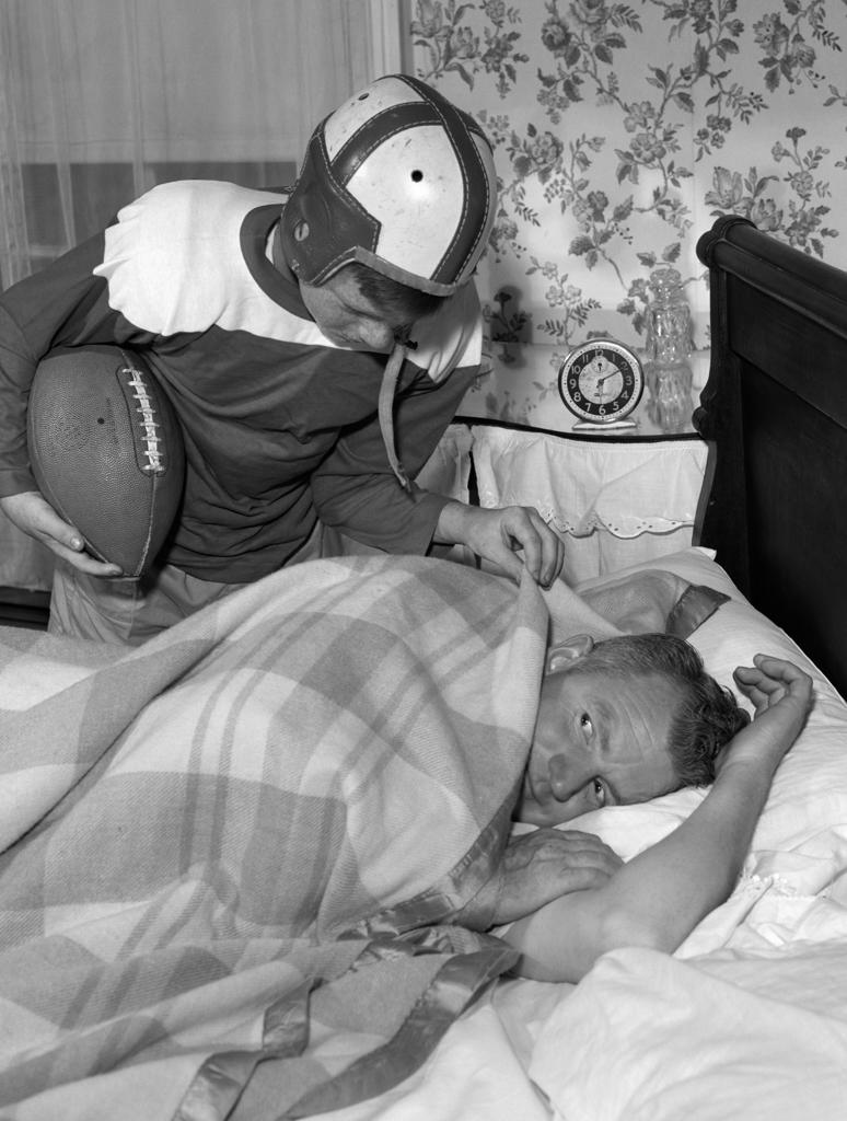 1950S Boy In Football Uniform Waking Up Father Early In Morning