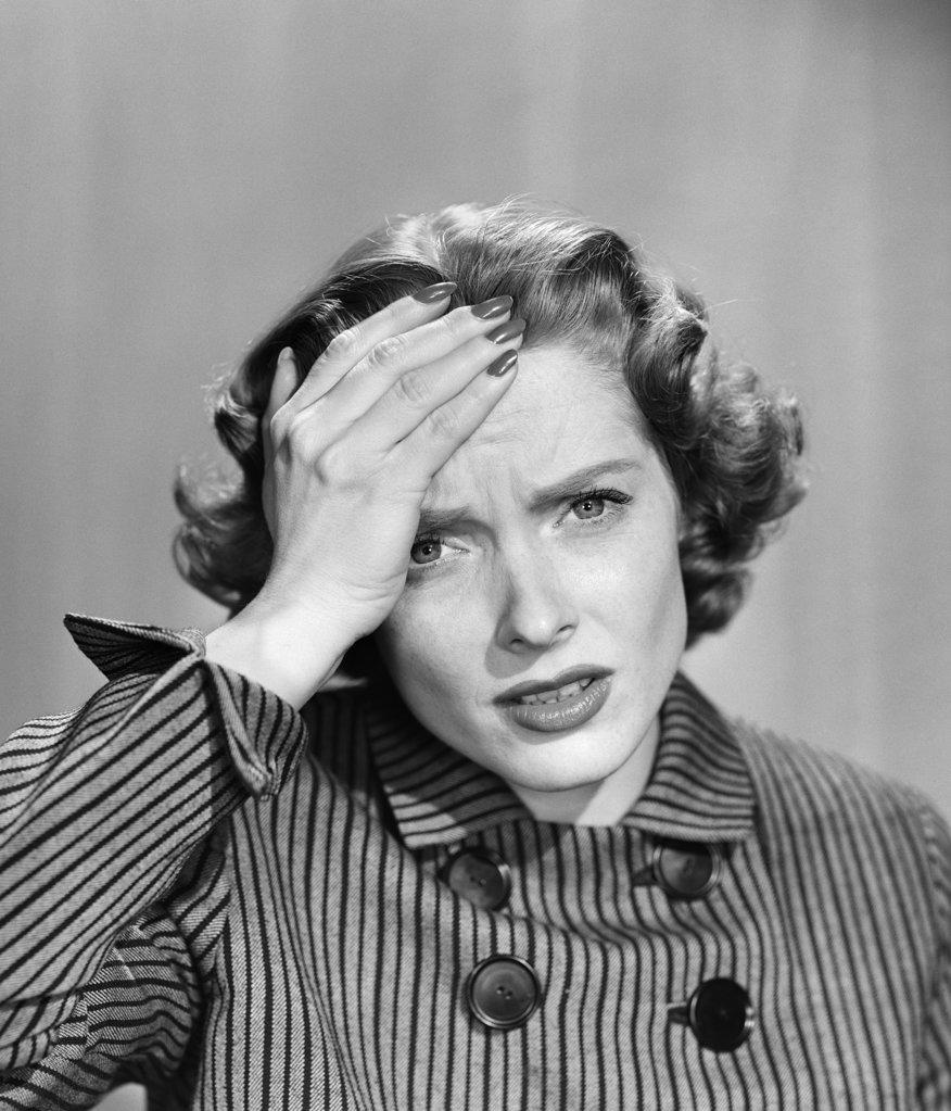 1950S Stressed Woman In Striped Dress Hold Forehead With Hand Looking At Camera