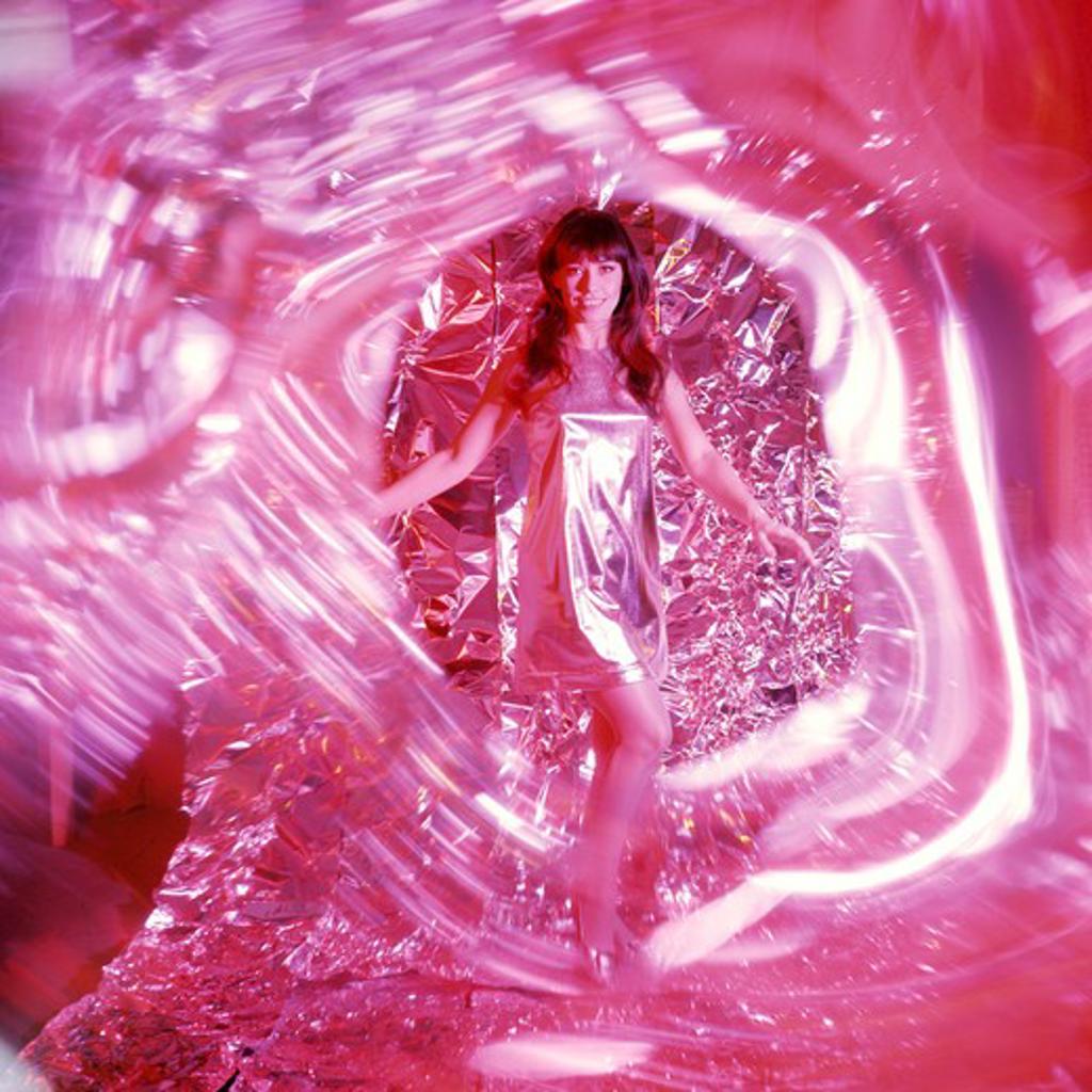 1960S 1970S Smiling Woman With Long Brunette Hair In Short Silver Lame Miniskirt Dress Dancing Amid Swirling Red Light And Foil Backdrop