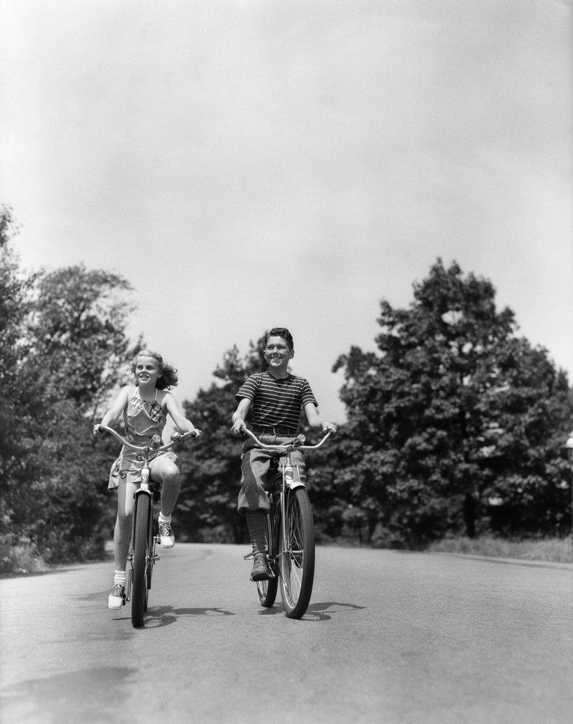 1940S Boy Girl Riding Bikes Down Country Lane