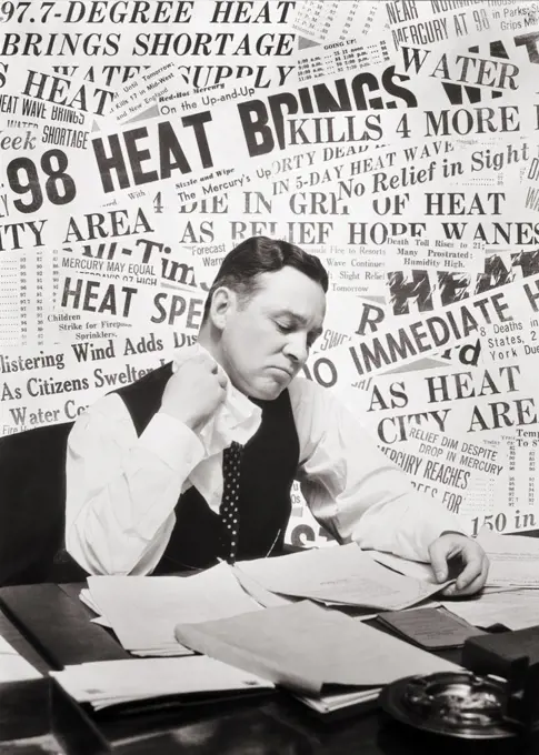 1930s SWEATING MAN SITTING AT DESK READING PAPERS USING HANDKERCHIEF WIPING HIS NECK BACKGROUND OF HEAT WAVE NEWSPAPER HEADLINES