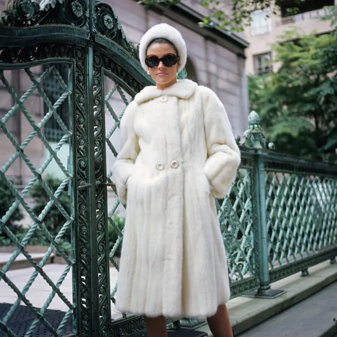 1960S Woman Wearing White Mink Fur Coat Hat Sunglasses By Wrought Iron Gate