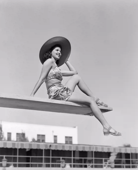 1930S Woman Wearing Hat Sitting Near Edge Of Diving Board