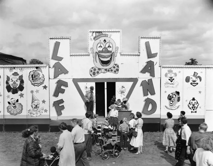 1950s LINE OF PEOPLE AT ENTRANCE TO FUNHOUSE BYING TICKETS AT LOCAL FAIR