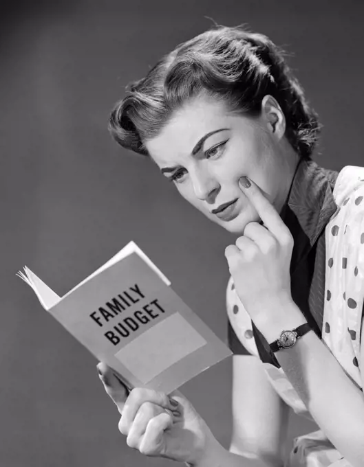 1950S Woman In Apron Finger On Cheek Looking At Family Budget Book