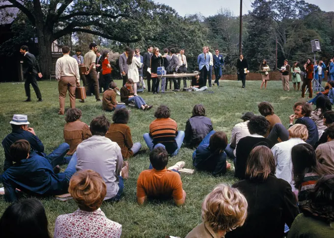 1970s PEACEFUL CAMPUS PROTEST DEMONSTRATION TEACH-IN STUDENTS STANDING SITTING ON LAWN SPEAKING ON AN ISSUE LONG ISLAND NY USA
