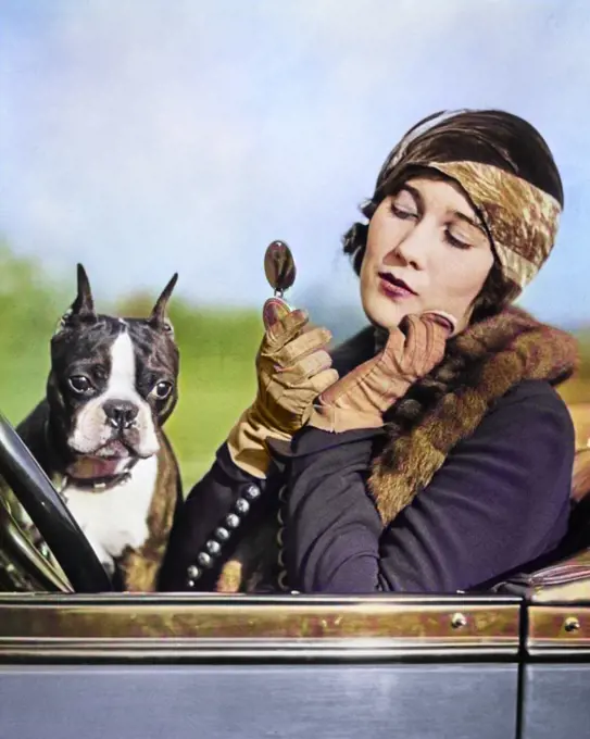 1920s WOMAN FLAPPER IN CONVERTIBLE POWDERING HER CHEEK IN MIRROR WITH BOSTON TERRIER IN HER LAP