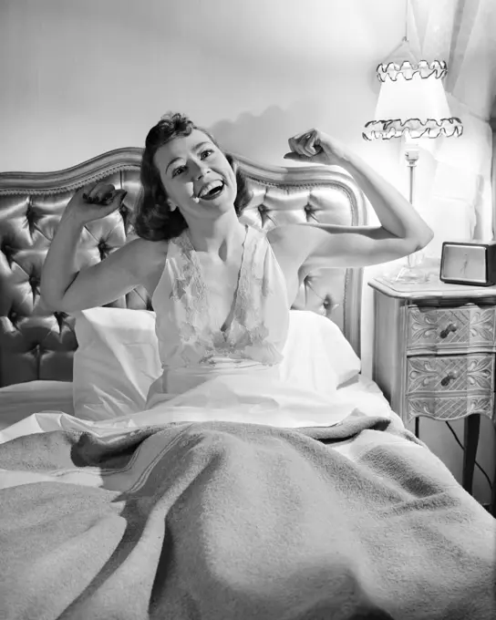 1940s 1950s WOMAN IN BED STRETCHING ARMS