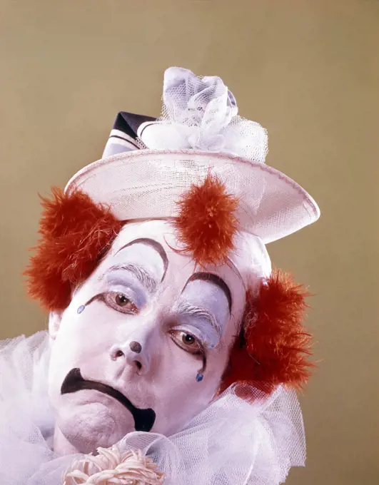 1970s PORTRAIT OF A SAD CLOWN BRIGHT ORANGE HAIR TUFTS LOOKING AT CAMERA 
