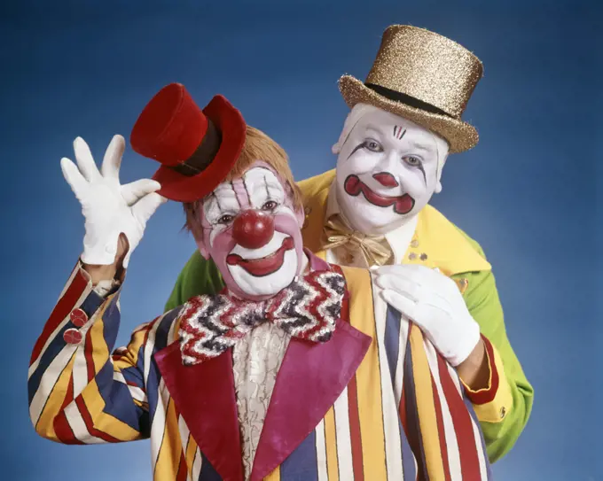 1970s PORTRAIT OF TWO SMILING CLOWNS LOOKING AT CAMERA