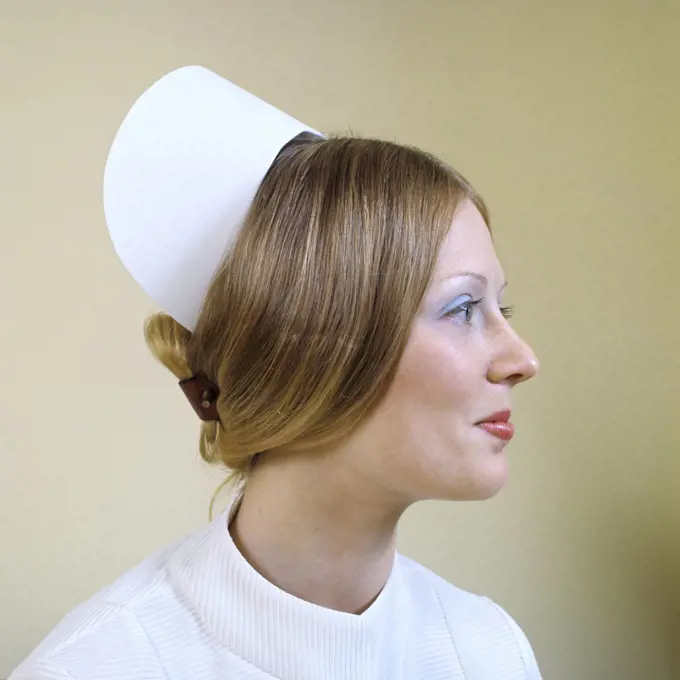 1970s PROFILE PORTRAIT REGISTERED NURSE WEARING CAP AND SLEEK HAIRSTYLE