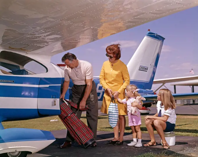 Family Putting Luggage On Private Plane