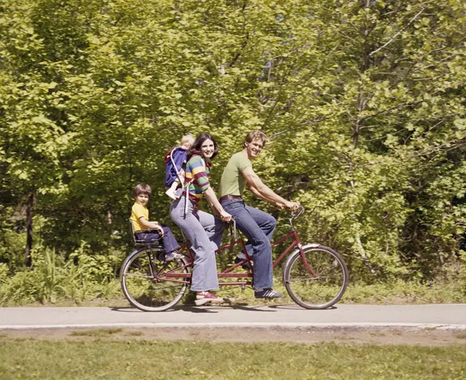 1970S Family On Tandem Bicycle Mother Father Son Back Seat Baby Daughter Backpack Wearing Bellbottom Blue Jeans