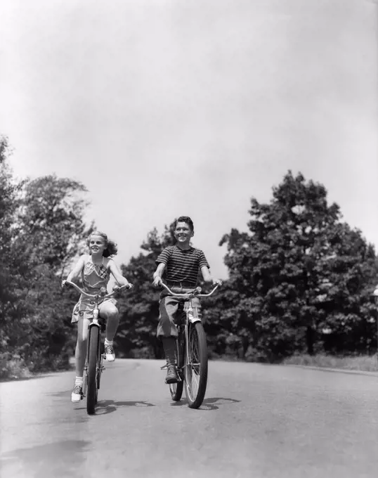 1940S Boy Girl Riding Bikes Down Country Lane