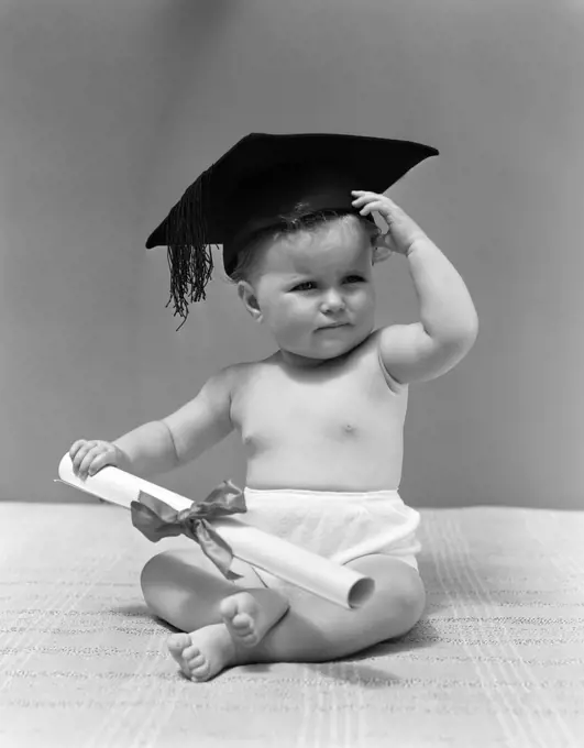 1940S Baby Wearing Mortar Board Graduation Cap And Holding Diploma