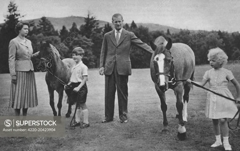 Prince Charles leading his pony William to his mother, Queen Elizabeth II. Princess Anne hold Greensleeves, patted by the Duke of Edinburgh, at Balmoral.  1955