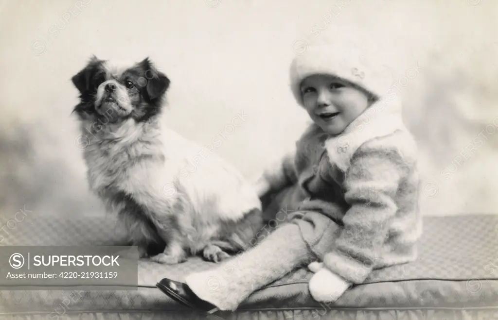Studio portrait of toddler and dog.      Date: circa 1930s