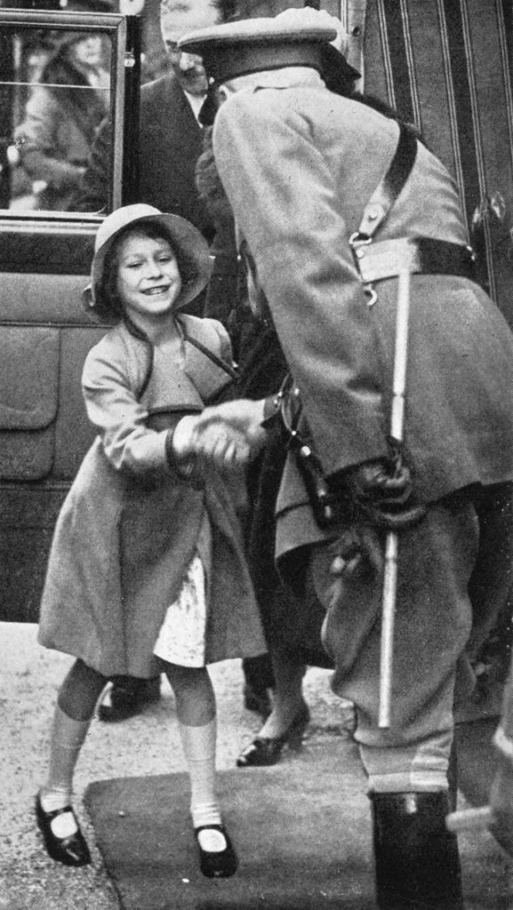 Princess Elizabeth is seen being greeted on her arrival at the daylight rehearsal of the Aldershot Tattoo, at which 50,000 school children were present.   1935