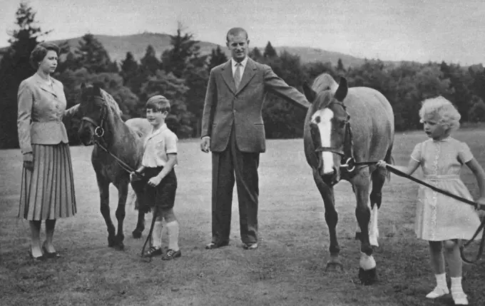 Prince Charles leading his pony William to his mother, Queen Elizabeth II. Princess Anne hold Greensleeves, patted by the Duke of Edinburgh, at Balmoral.  1955
