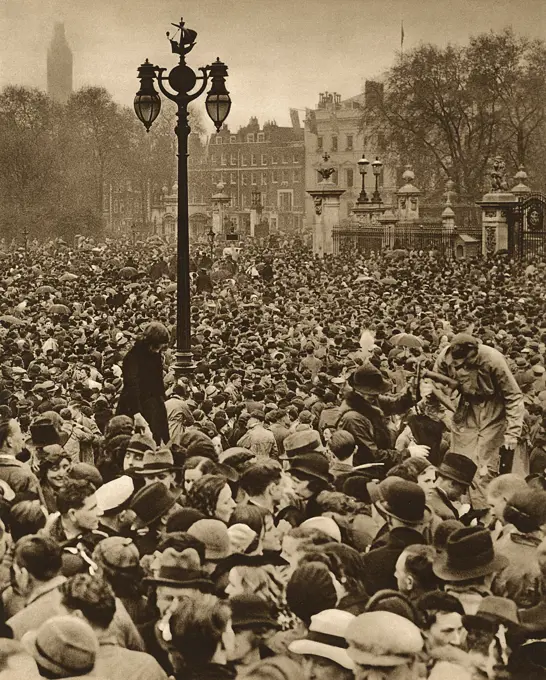 Crowds gathered outside Buckingham Palace to await the appearance of the newly crowned King George VI and Queen Elizabeth, following their Coronation at Westminster Abbey on 12 May 1937.     Date: 1937