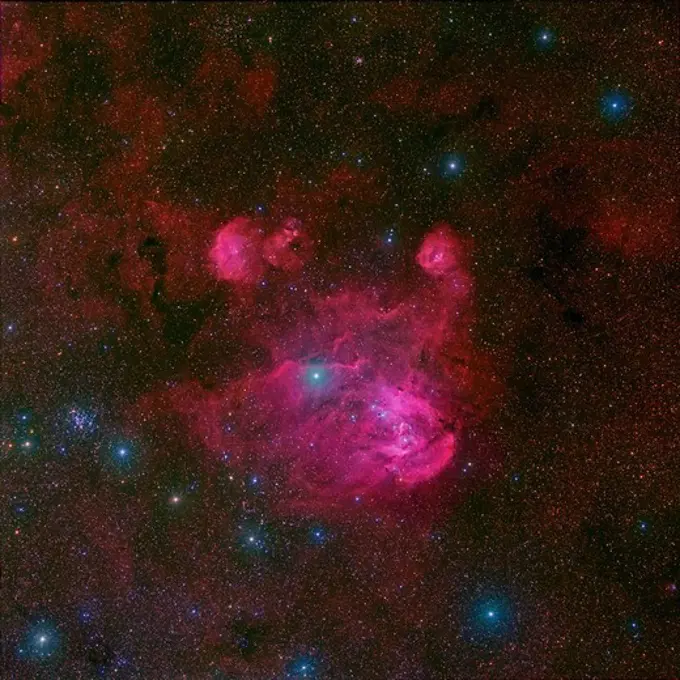 IC 2944, a large H II region (star forming cloud) in the southern constellation of Centaurus. The bright blue star near the center is Lambda Centauri. The cluster of hot blue stars in the center are illuminating the gases of IC2944 and causing it to glow in the red and magenta light of excited hydrogen. The compact cluster of blue stars on the left is NGC 3766 and the more subtle cluster near the top left is IC 2714.