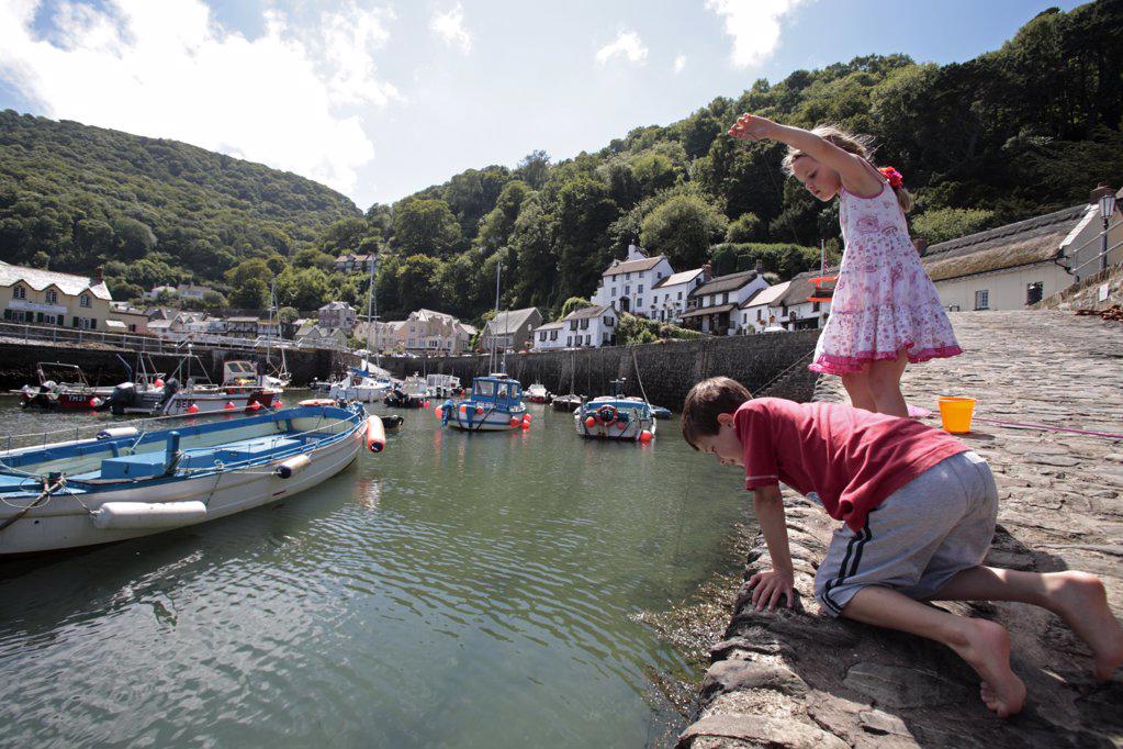 England, Devon, Lynmouth. Children crabbing from the habour wall. (MR)