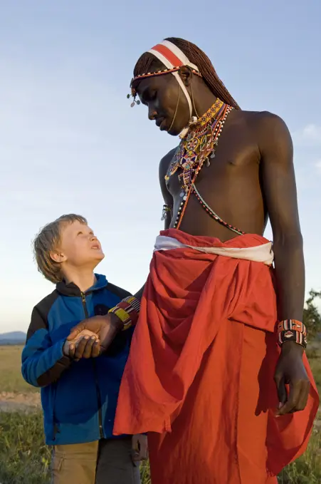 Kenya, Laikipia, Lewa Downs.  A young boy on a family safari with one of the Laikipiak Maasai guides. (MR)