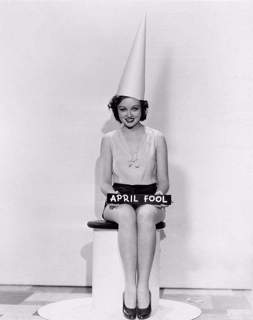 Portrait of woman with April Fool sign wearing dunce cap All persons depicted are not longer living and no estate exists Supplier warranties that ther...