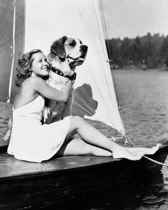 Woman and dog on sailboat All persons depicted are not longer living and no estate exists Supplier warranties that there will be no model release issu...