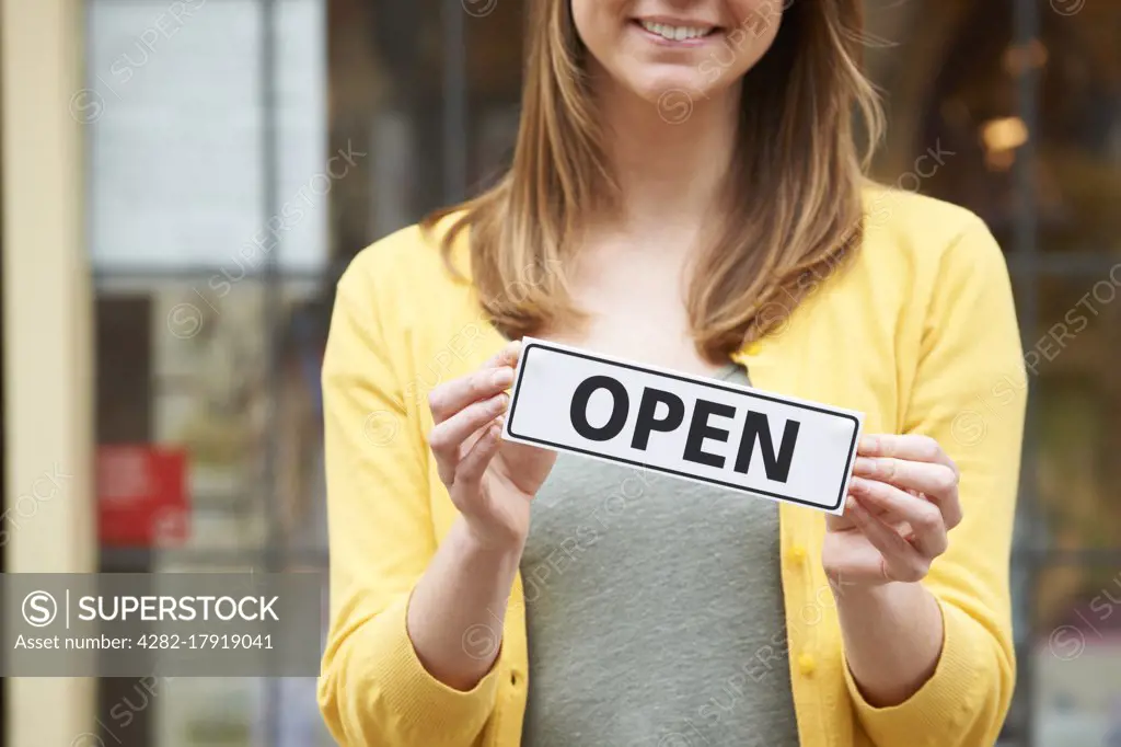 Detail Of Woman Holding Open Sign Outside Shop