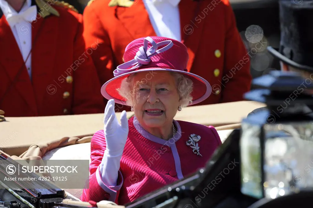 England, Berkshire, Ascot. HRH Queen Elizabeth II waving to the crowd from her carriage in the Royal procession during day two of Royal Ascot 2010.
