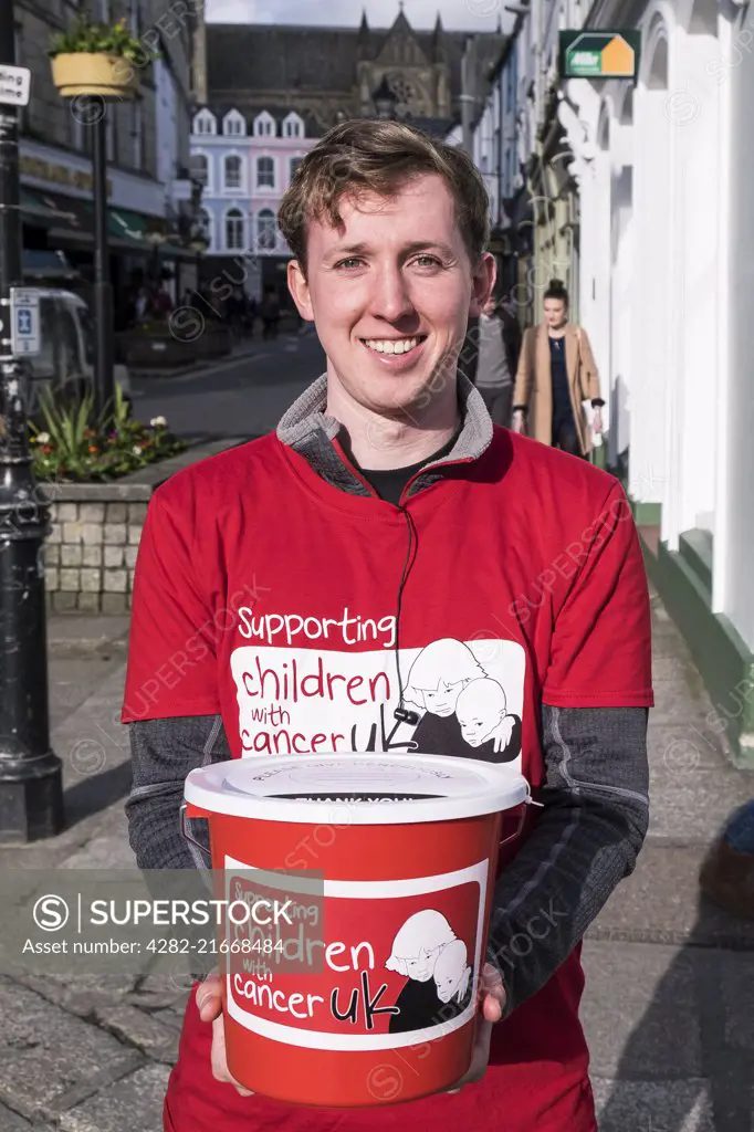 A volunteer collecting donations for Children with Cancer UK.