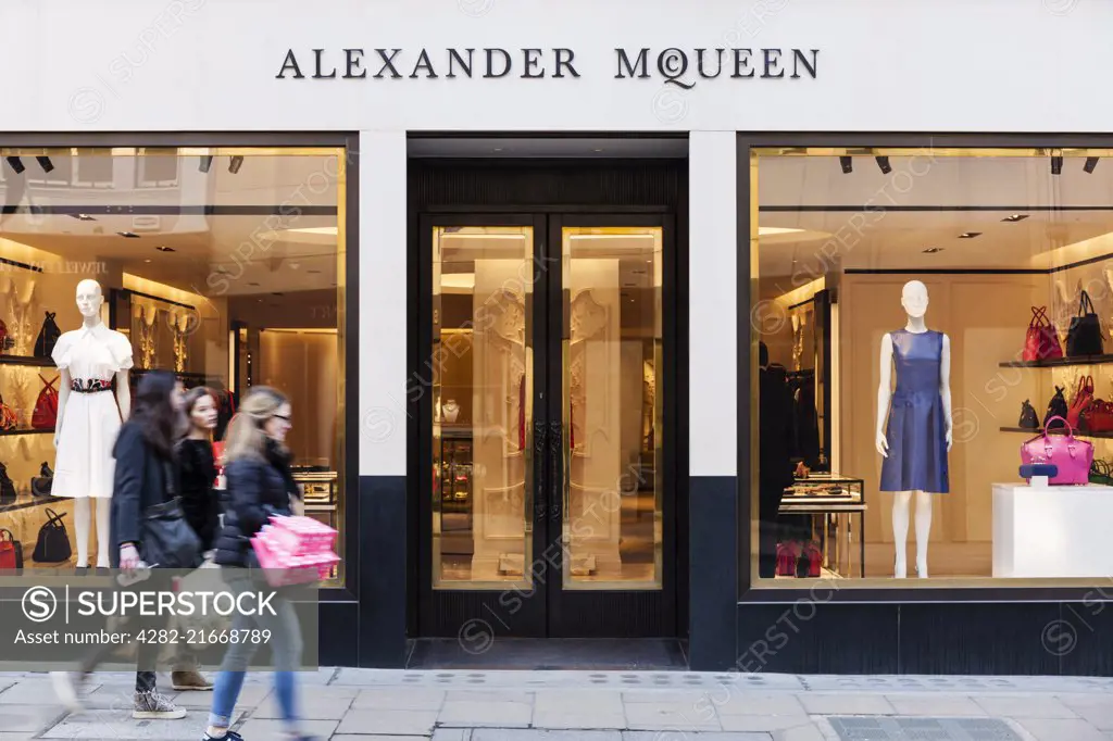 A group of young women walk by the Alexander McQueen fashion store on Old Bond Street.