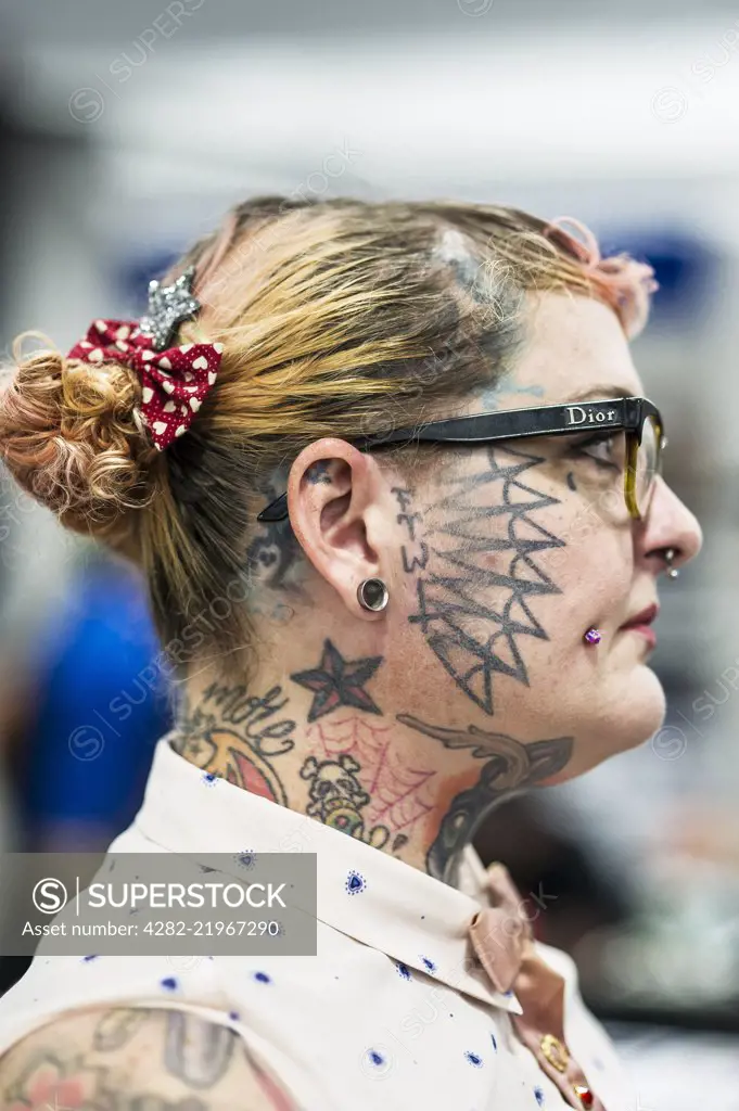 A profile view of female tattooist Julia Seizure at the Cornwall Tattoo Convention. - SuperStock