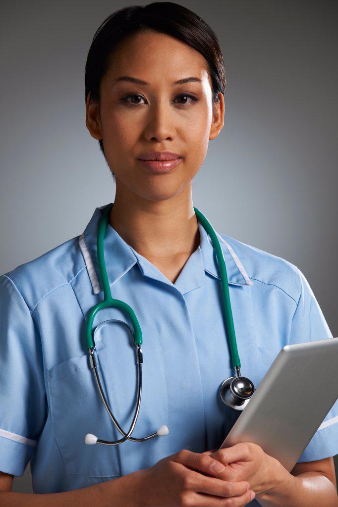 Studio Portrait Of Nurse With Digital Tablet