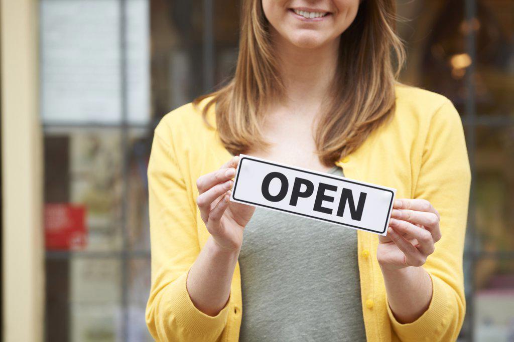 Detail Of Woman Holding Open Sign Outside Shop
