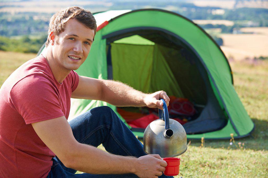 Young Man Camping In Countryside